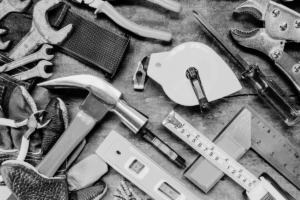 Photo noir et blanv d'outils de bricolages posés en vrac sur une table
